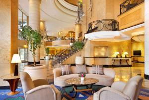 a lobby with chairs and tables and a staircase at Hilton Sandton in Johannesburg