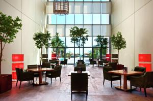 a restaurant with tables and chairs and a large window at Hilton Kuwait Resort in Kuwait