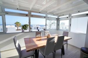 Un comedor con mesa y sillas de madera. en Rooftop sea view with Jacuzzi and A/C, en Puerto del Carmen