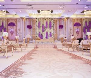 um salão de banquetes com mesas, cadeiras e lustres em Hilton Kuwait Resort em Kuwait