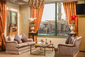 a living room with two chairs and a table and a window at Madinah Hilton Hotel in Medina