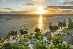 eine Luftansicht auf das Resort und das Meer bei Sonnenuntergang in der Unterkunft Hilton Mauritius Resort & Spa in Flic-en-Flac