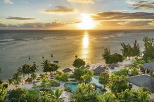 een luchtzicht op het resort en de oceaan bij zonsondergang bij Hilton Mauritius Resort & Spa in Flic-en-Flac