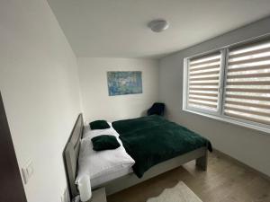 1 dormitorio con 1 cama con manta verde en Víkendový dom Lilac en Liptovská Štiavnica