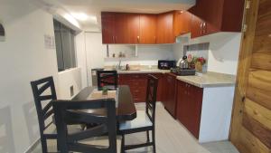 una cocina con armarios de madera, mesa y sillas en Apartamento en Cusco II, en Cusco