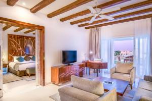 a living room with a bed and a tv at Hilton Marsa Alam Nubian Resort in Abu Dabbab