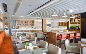 a restaurant with tables and chairs and a bar at Hilton Garden Inn Ras Al Khaimah in Ras al Khaimah