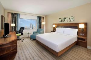 a hotel room with a bed and a desk and a television at Hilton Garden Inn Ras Al Khaimah in Ras al Khaimah