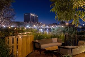 een patio met een bank, stoelen en een tafel bij Radisson Hotel Tamboho Waterfront Antananarivo in Antananarivo