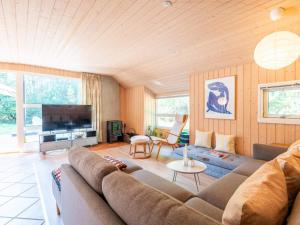 ein Wohnzimmer mit einem Sofa und einem TV in der Unterkunft Holiday home Nørre Nebel III in Nørre Nebel