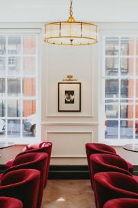 una sala riunioni con sedie rosse e lampadario a braccio di Lock and Key Boutique Hotel - Duke Street a Liverpool