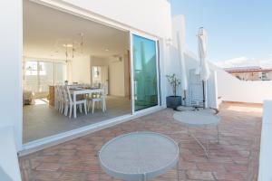 a living room and dining room with a table and chairs at Casa do Ser in Fuzeta