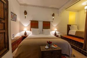 Un dormitorio con una cama y una mesa con flores. en Les Sources Berbères Riad & Spa en Marrakech
