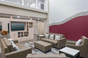 Il comprend un salon avec des canapés et une télévision à écran plat. dans l'établissement Magnolia Pointe; BW Signature Collection, à Sarasota