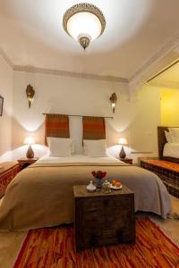 a bedroom with a large bed and a table at Les Sources Berbères Riad & Spa in Marrakesh