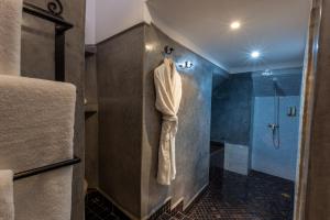 a bathroom with a shower and a towel hanging on a wall at Les Sources Berbères Riad & Spa in Marrakesh
