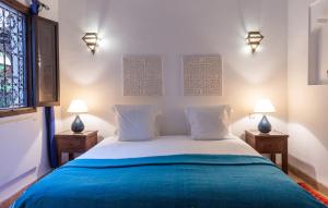 a bedroom with a bed with two lamps on two tables at Les Sources Berbères Riad & Spa in Marrakech