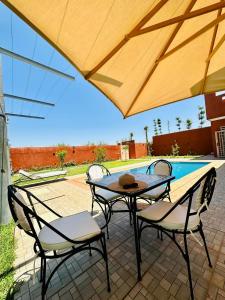 馬拉喀什的住宿－Villa hidaya sans vis à vis，一个带桌椅的庭院和一个游泳池