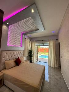 een slaapkamer met een bed met een paars licht erboven bij Villa hidaya sans vis à vis in Marrakesh