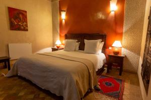 a bedroom with a large bed with two lamps on two tables at Les Sources Berbères Riad & Spa in Marrakech +46 photos