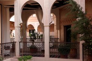 a building with arches and a balcony with plants at Les Sources Berbères Riad & Spa in Marrakesh