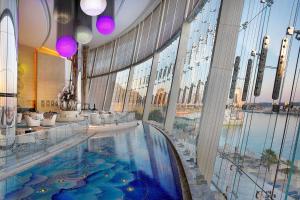 a large indoor swimming pool in a building with a large window at Conrad Abu Dhabi Etihad Towers in Abu Dhabi