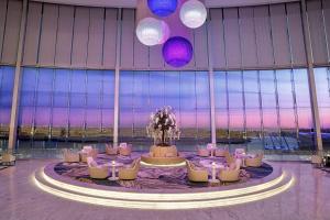 uma grande sala com mesas e cadeiras num edifício em Conrad Abu Dhabi Etihad Towers em Abu Dhabi
