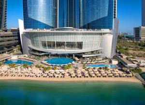 an aerial view of a resort with chairs and pools at Conrad Abu Dhabi Etihad Towers in Abu Dhabi