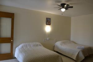 オアハカにあるCasa Shanti Oaxacaのベッドルーム1室(ベッド2台、シーリングファン付)