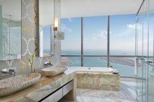 a bathroom with two sinks and a tub with a view at Conrad Abu Dhabi Etihad Towers in Abu Dhabi