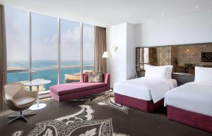 a hotel room with two beds and a view at Conrad Abu Dhabi Etihad Towers in Abu Dhabi