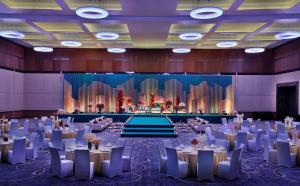 a banquet hall with tables and chairs and a stage at Conrad Abu Dhabi Etihad Towers in Abu Dhabi +37 photos