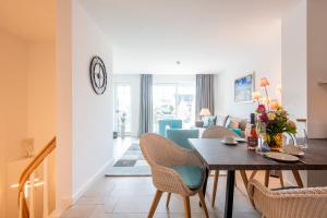 a dining room and living room with a table and chairs at Haus Dünenweg Whg 2 in Hörnum