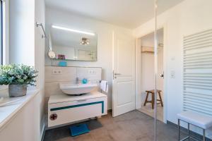 a bathroom with a sink and a mirror at Haus Dünenweg Whg 2 in Hörnum +50 photos