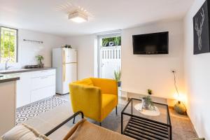 a living room with a yellow chair and a kitchen at Perfect Apartment Jaffa Beach in Tel Aviv
