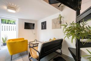 a living room with yellow chairs and a tv at Perfect Apartment Jaffa Beach in Tel Aviv