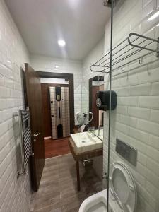 ein Badezimmer mit einem Waschbecken, einem WC und einem Spiegel in der Unterkunft Konak suit in Istanbul