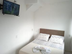 a bedroom with a bed with a towel on it at #Tribo Suítes no alto do morro in Morro de São Paulo