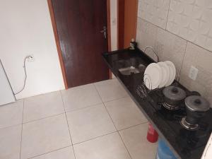 cocina con fregadero y encimera con ollas y sartenes en #Tribo Suítes no alto do morro, en Morro de São Paulo