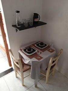 una mesa con dos platos y vasos. en #Tribo Suítes no alto do morro, en Morro de São Paulo