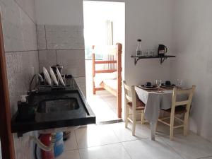 cocina con fregadero y mesa con sillas en #Tribo Suítes no alto do morro, en Morro de São Paulo