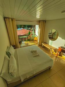 a bedroom with a large bed and a large window at Pousada Água de Fuego in Maragogi