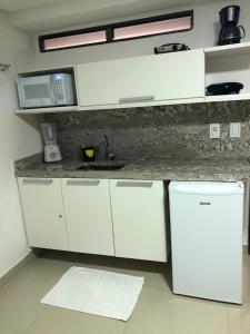 a white kitchen with a sink and a microwave at Gold Flat Cabo Branco in João Pessoa