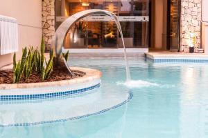a fountain in a swimming pool in a building at Fonte Arcada in Villa Gesell