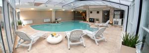 a large swimming pool with chairs and a table and a tablektop at Fonte Arcada in Villa Gesell