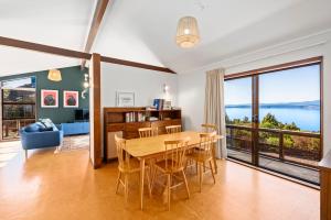 une salle à manger avec une table et des chaises et une grande fenêtre dans l'établissement Lakeside Stunner - Omori Holiday Home, à Kuratau