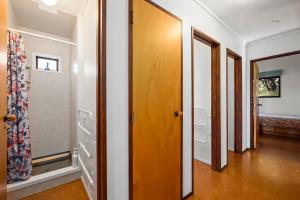 un couloir avec plusieurs portes dans une maison dans l'établissement Lakeside Stunner - Omori Holiday Home, à Kuratau 23 autres photos