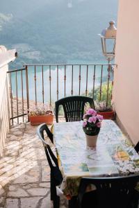 Lago del Turano - La Taverna con cucina open space e free WI-FI في Ascrea: طاولة وكراسي على شرفة مطلة على المحيط