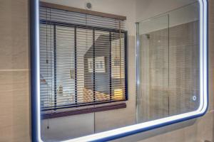 a mirror in a bathroom with a window with blinds at Le Loft 39 - CHU in La Tronche