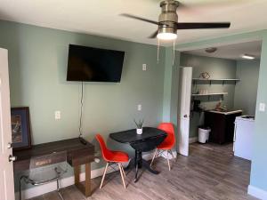 a dining room with a table and two red chairs at Cottage close to French Quarters in New Orleans